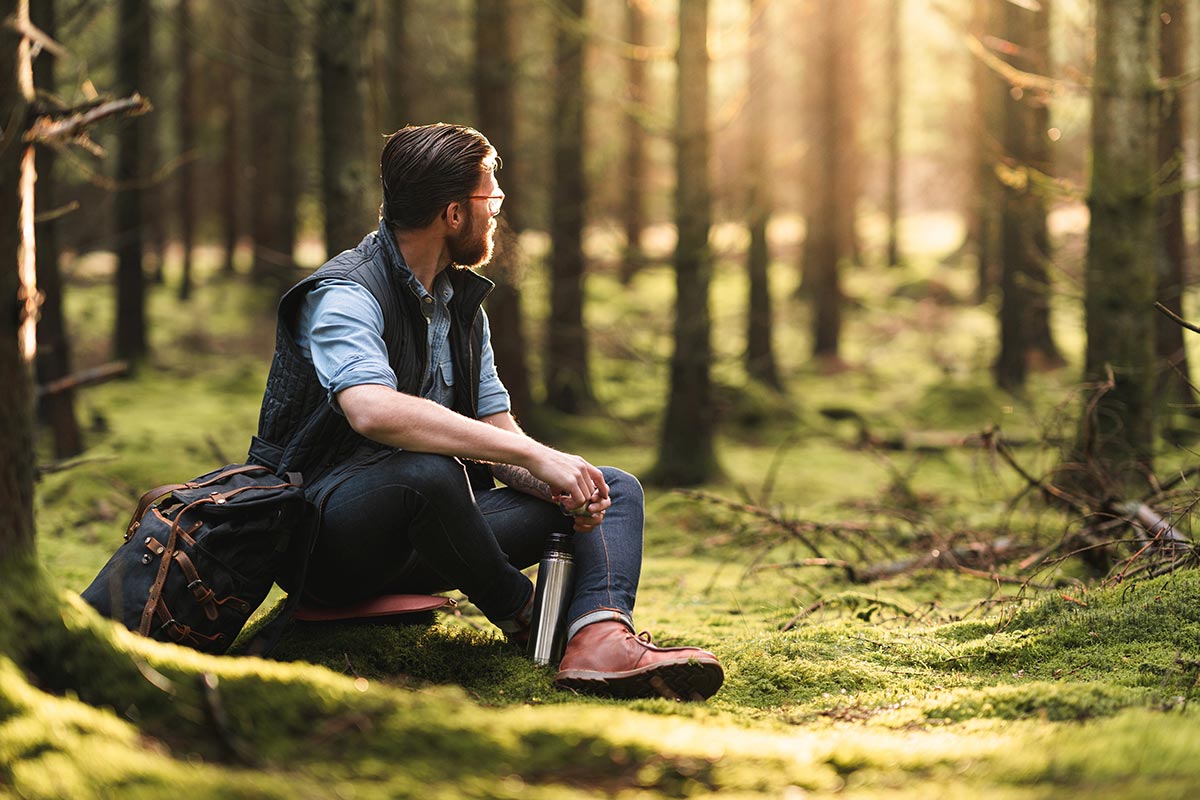 Ein Mann sitzt in der Natur - VitaeLab engagiert sich für Nachhaltigkeit